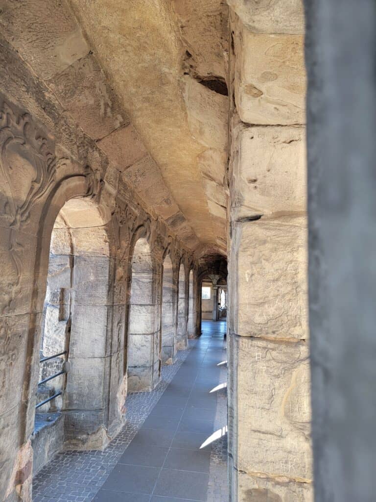 A long passage with stone arches down the left side