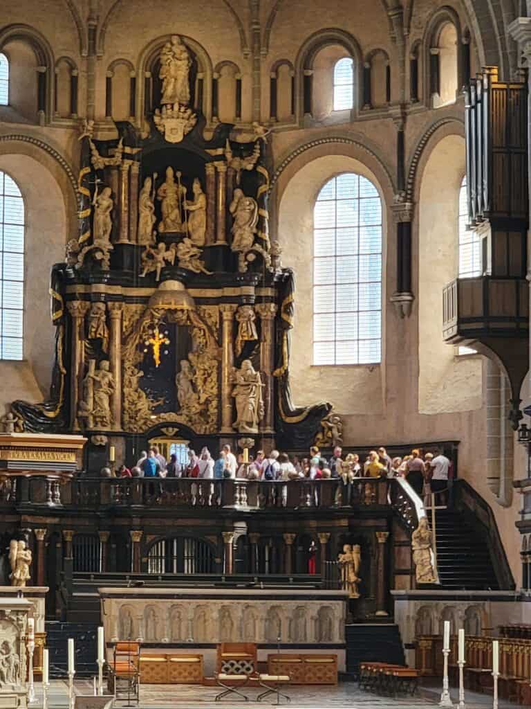 A tour group stands near the alter of Trier cathedral