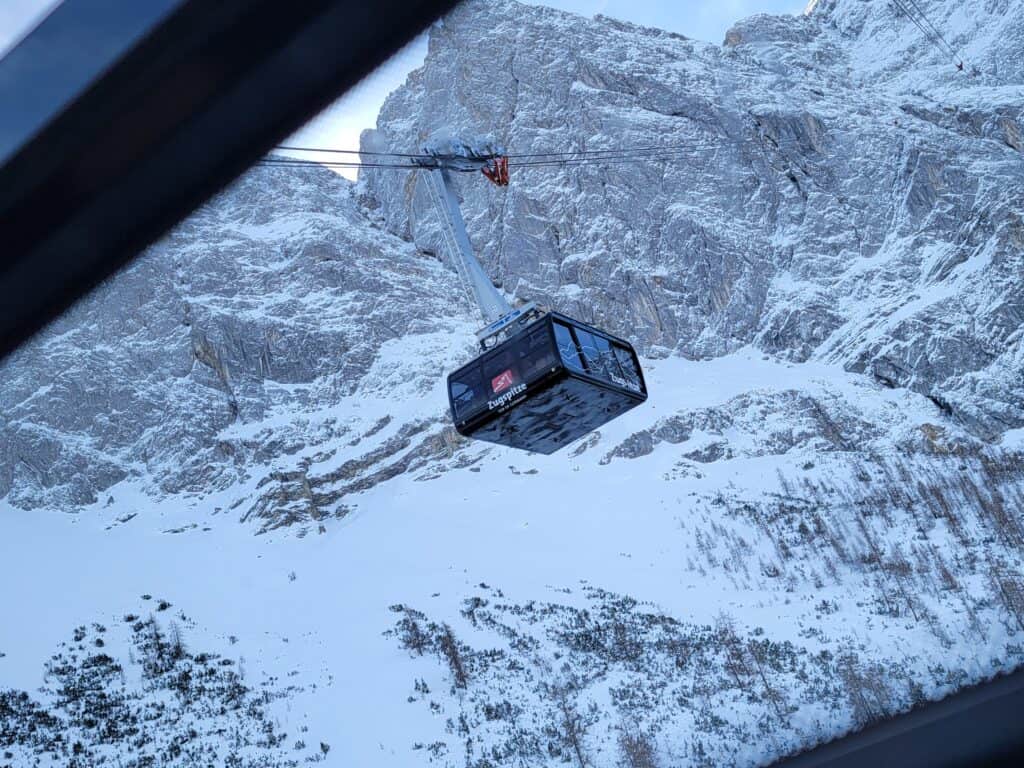 A Zugspitze cable car with snowy mountains in the background