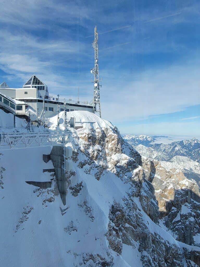 Observation deck on Zugspize from the cable car with snowy mountains and blue sky