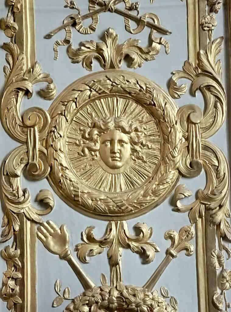 An image of Louis XIV as The Sun King on the gate of Versailles