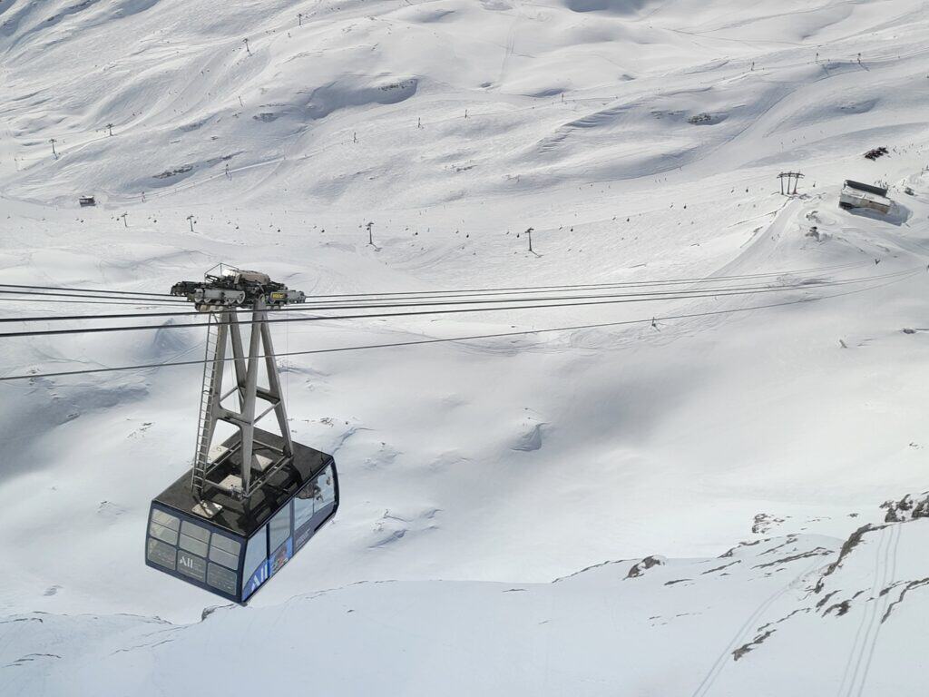 View of a snowy field with the Zugspitze cable car ascending