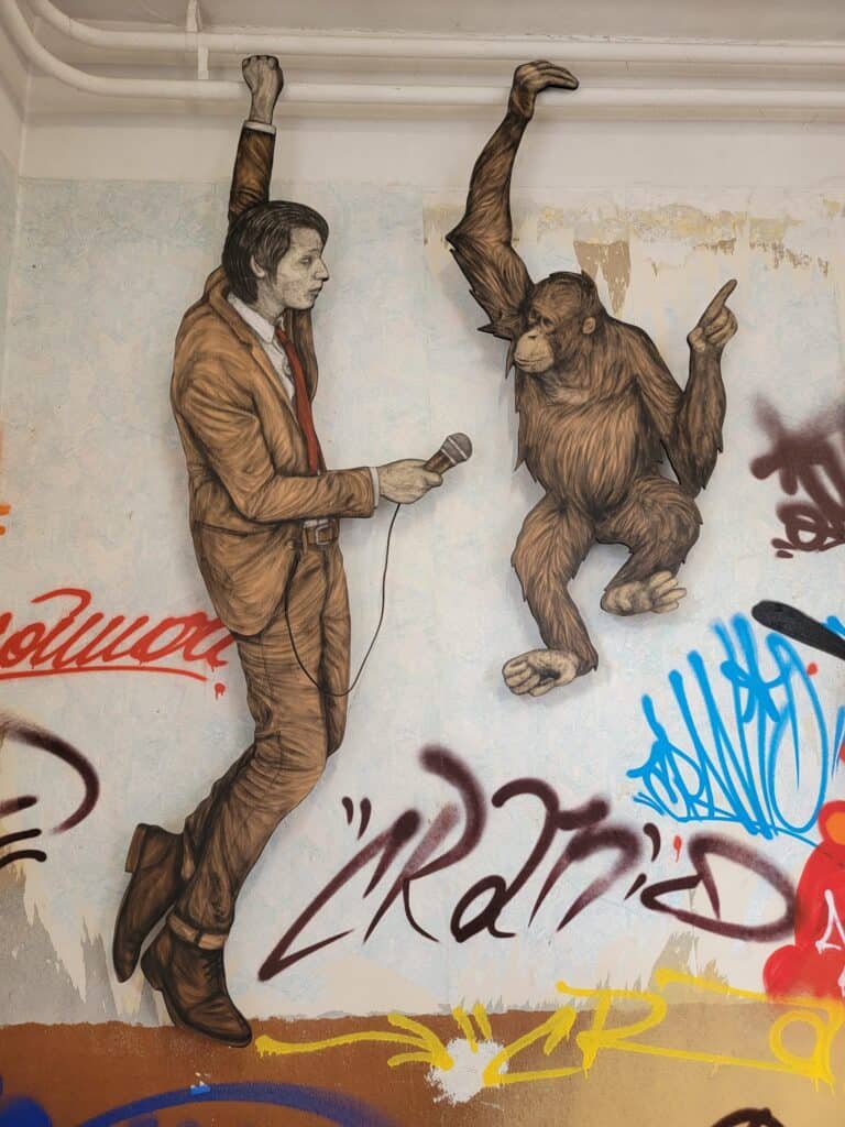 Man interviewing orangutan at the Museum of Urban and Street Art in Bitche, France.