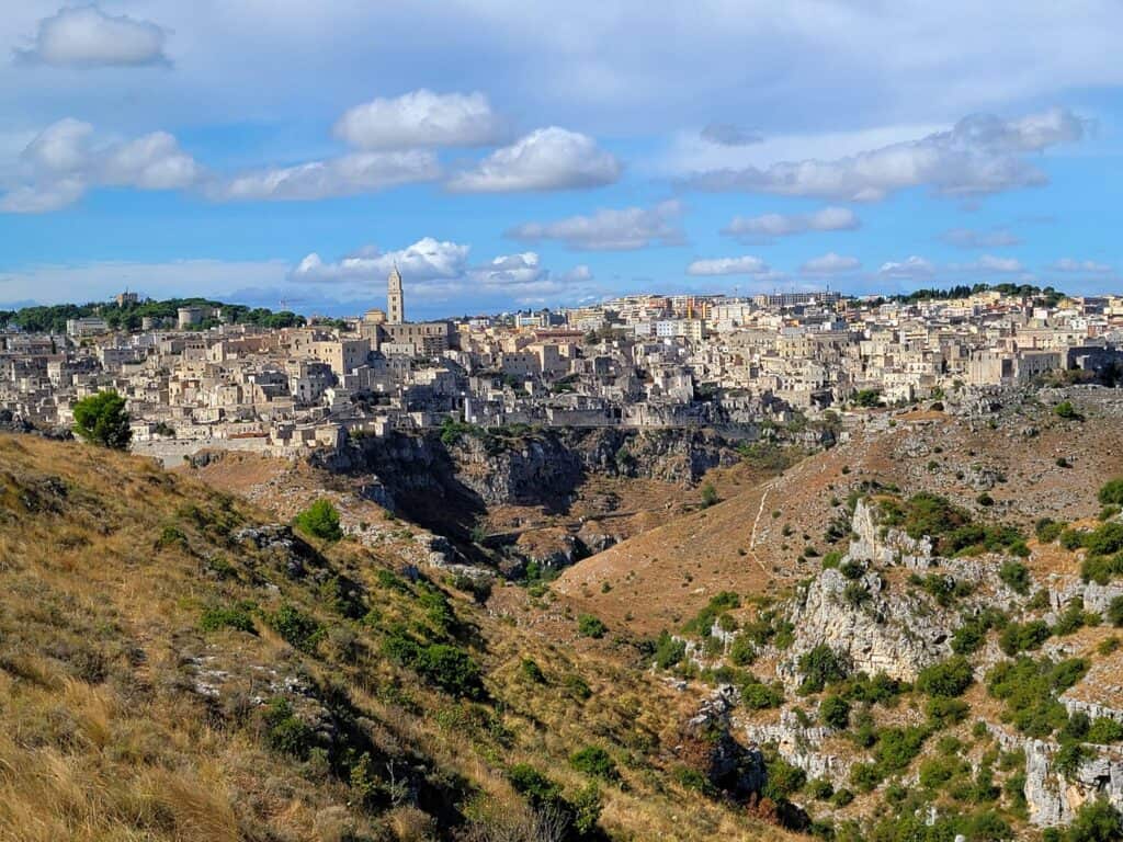 A large bowl-shaped gorge ringed by a stone city, densely built with a spire on the left