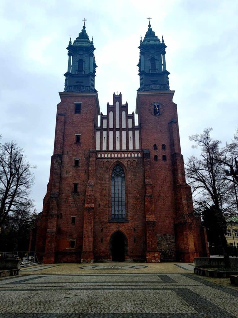 The facade of Poznan cathedral with two towers made of red brick