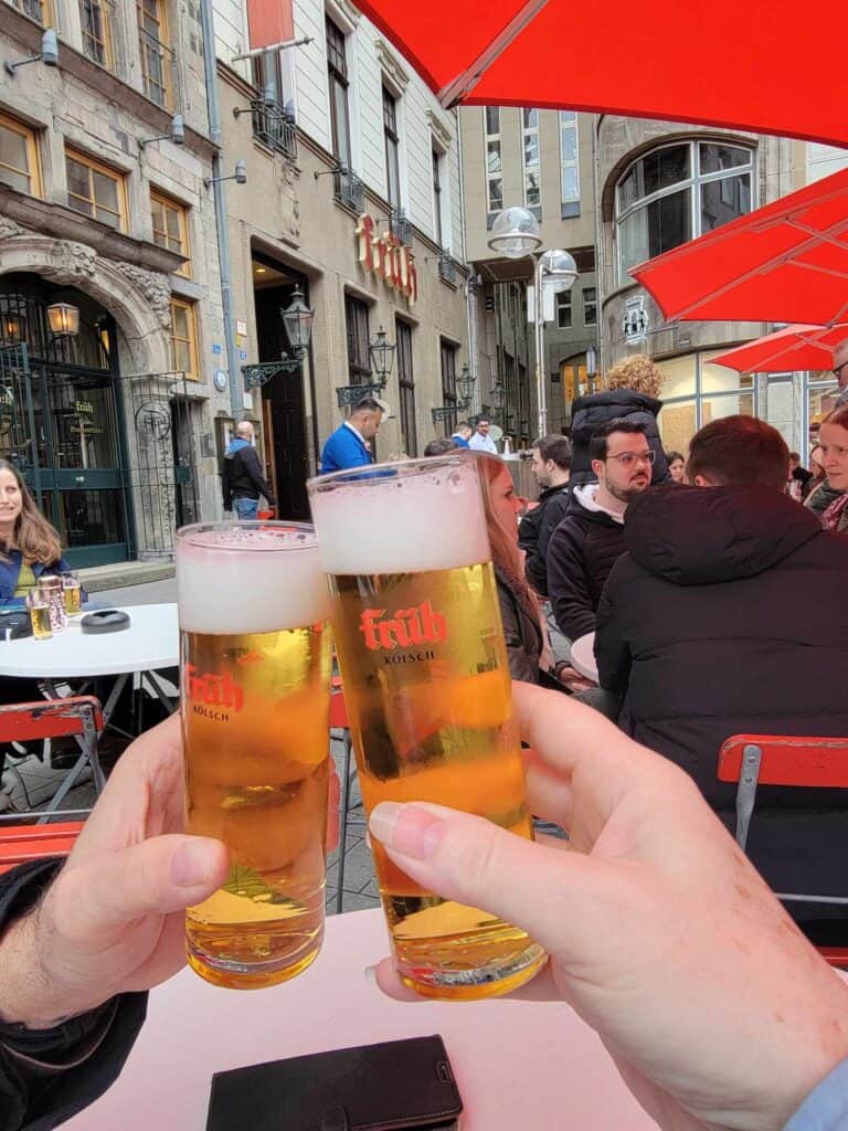 Two hands holding and toasting with glasses of Kolsch beer