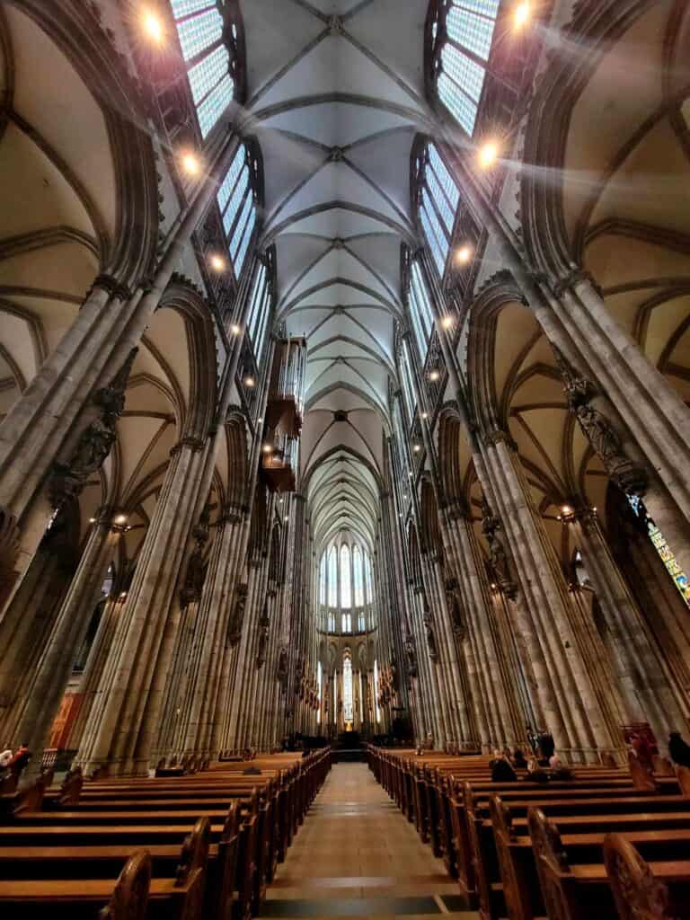 The interior of Cologne cathedral with tall columns and vaulted arches