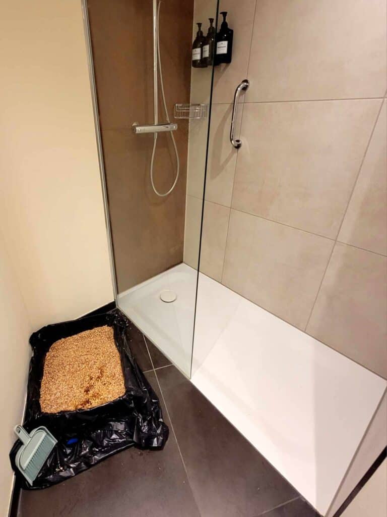 A hotel bathroom with a litter box set up in it