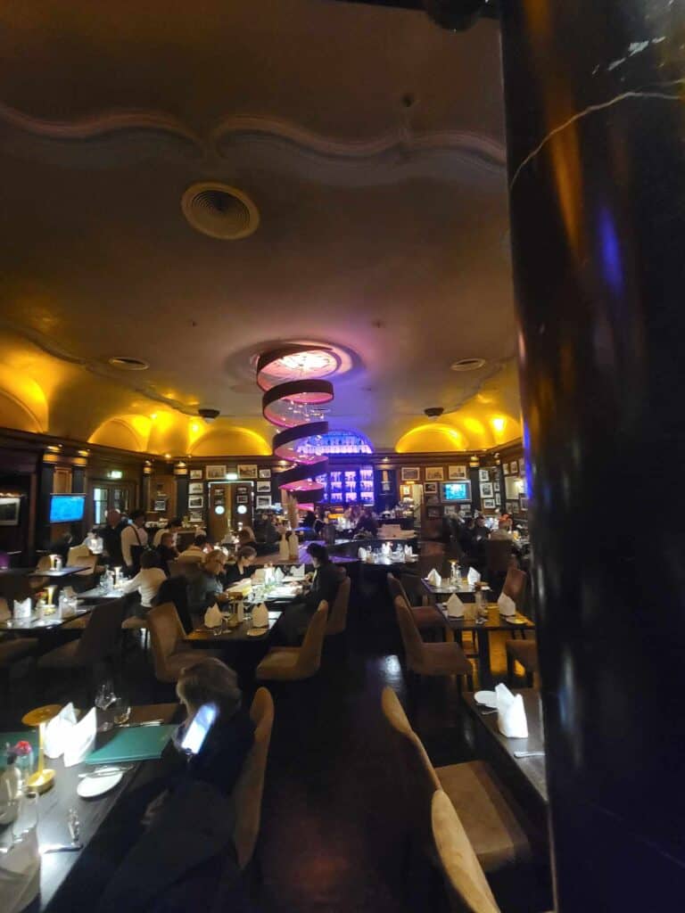 The inside of Wasertaal restaurant in Cologne with dark wood, yellow domed lights and tables set for dinner