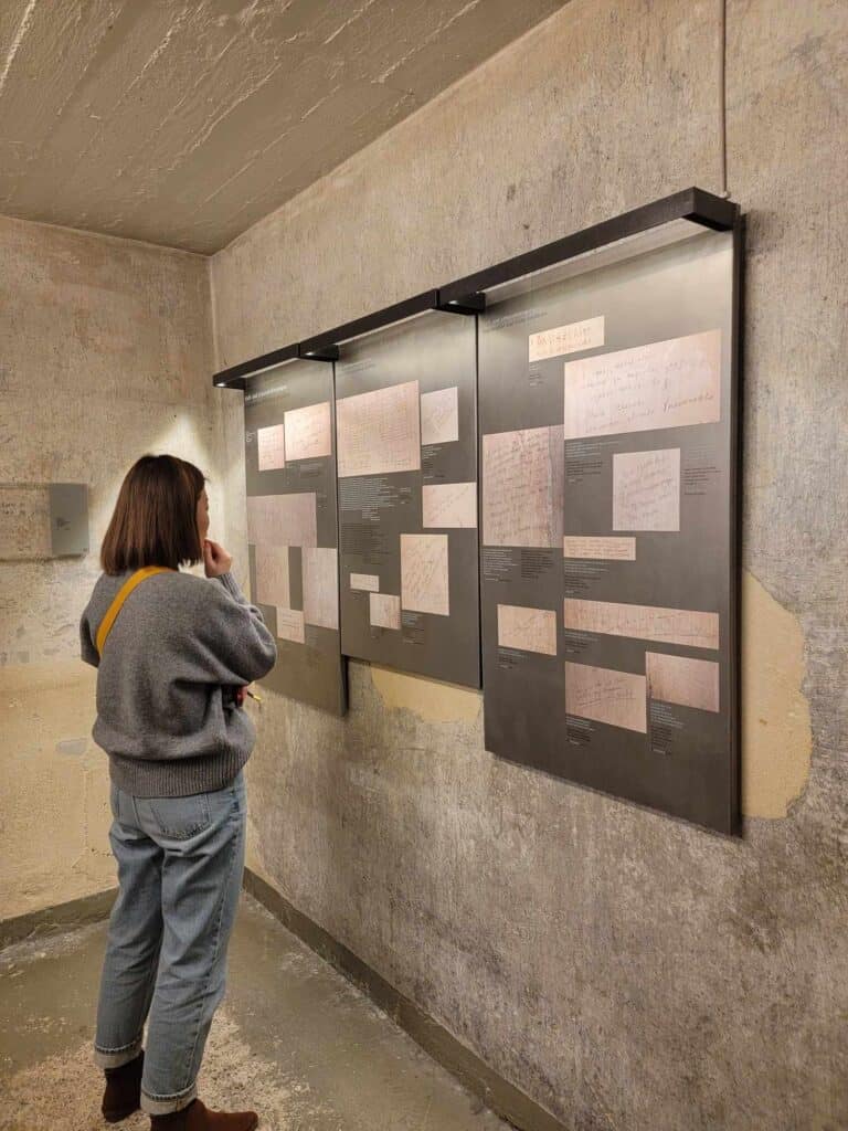 A woman stands reading notes on the walls