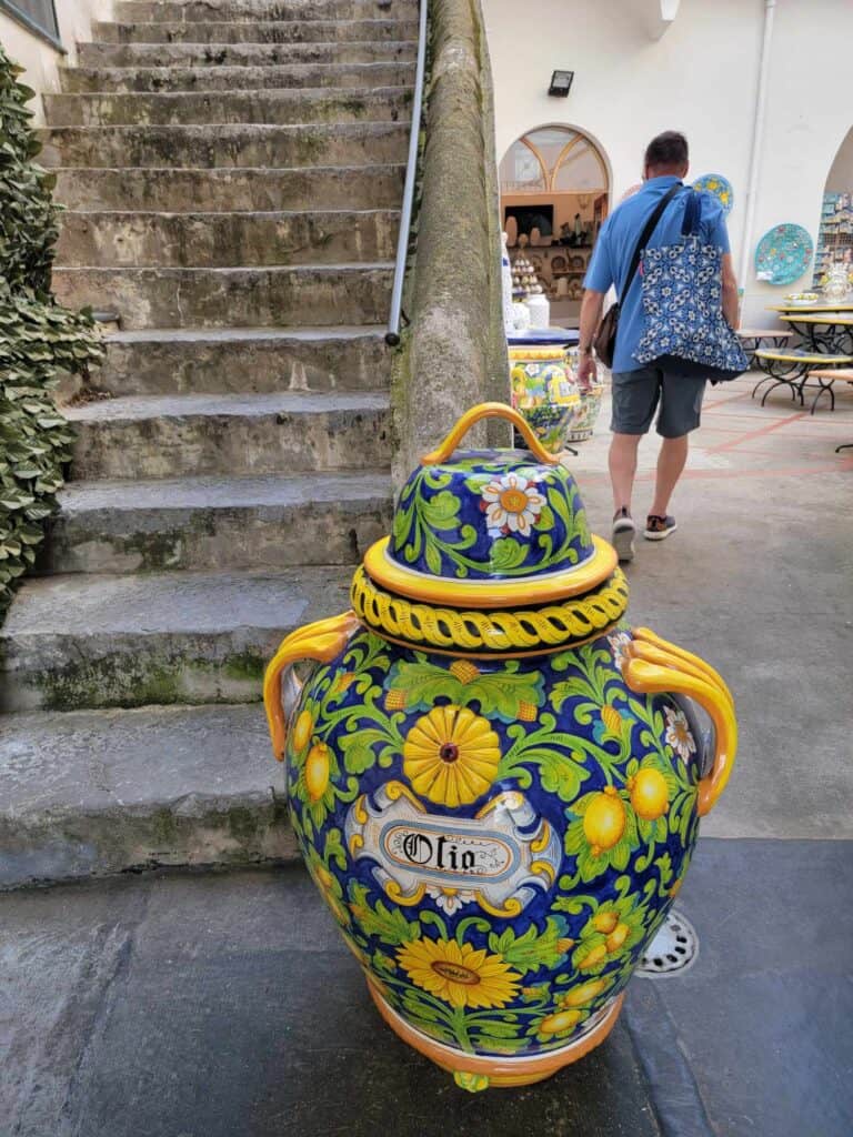 A large ceramic olive oil container painted with yellow flowers