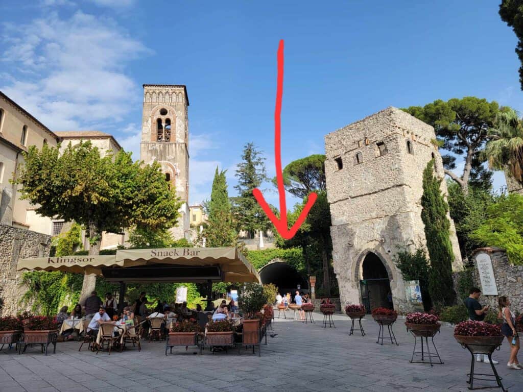 An outdoor dining terrace, with the entrance to Villa Rufolo in Ravello Italy