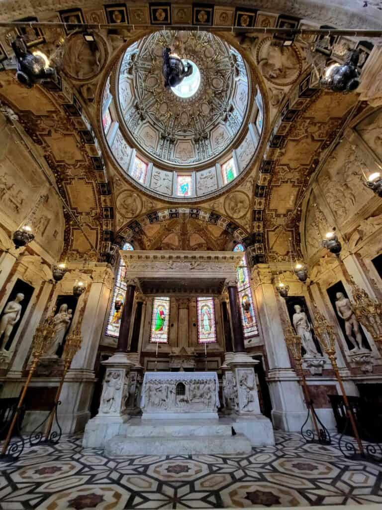 A marble altar under a large painted dome with many little windows