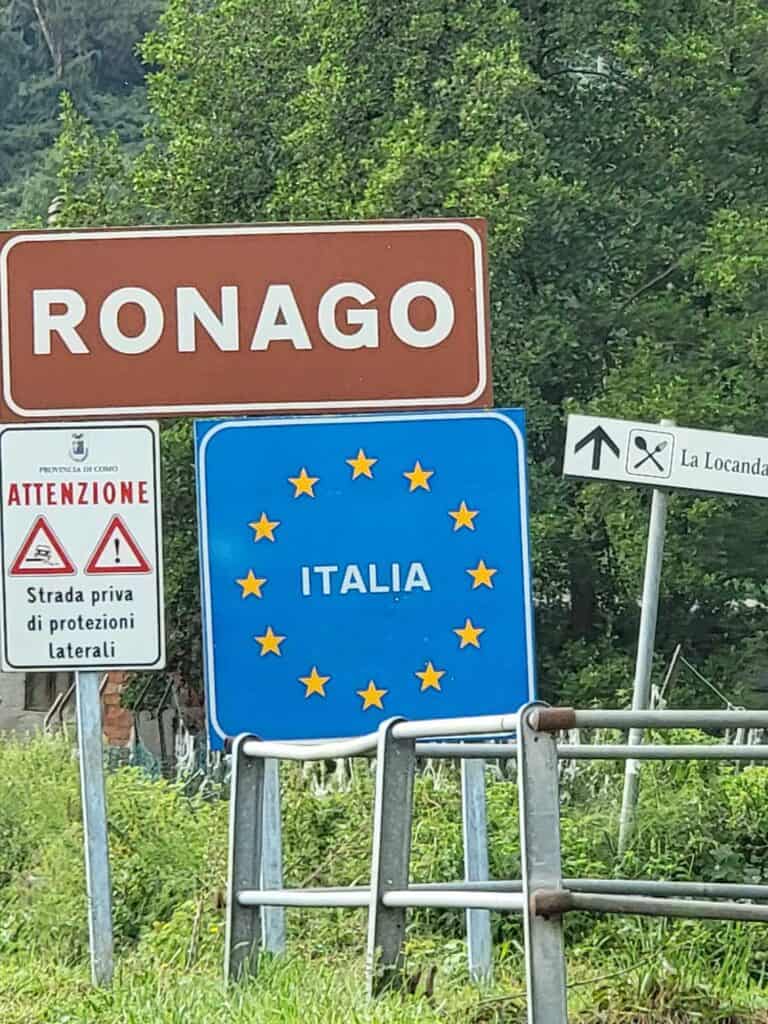 A square blue sign with the gold stars of the EU reads ITALIA at the border between Switzerland and Italy