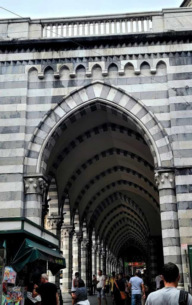 A long row of pointed arches in stripes of black and white marble with striped support columns