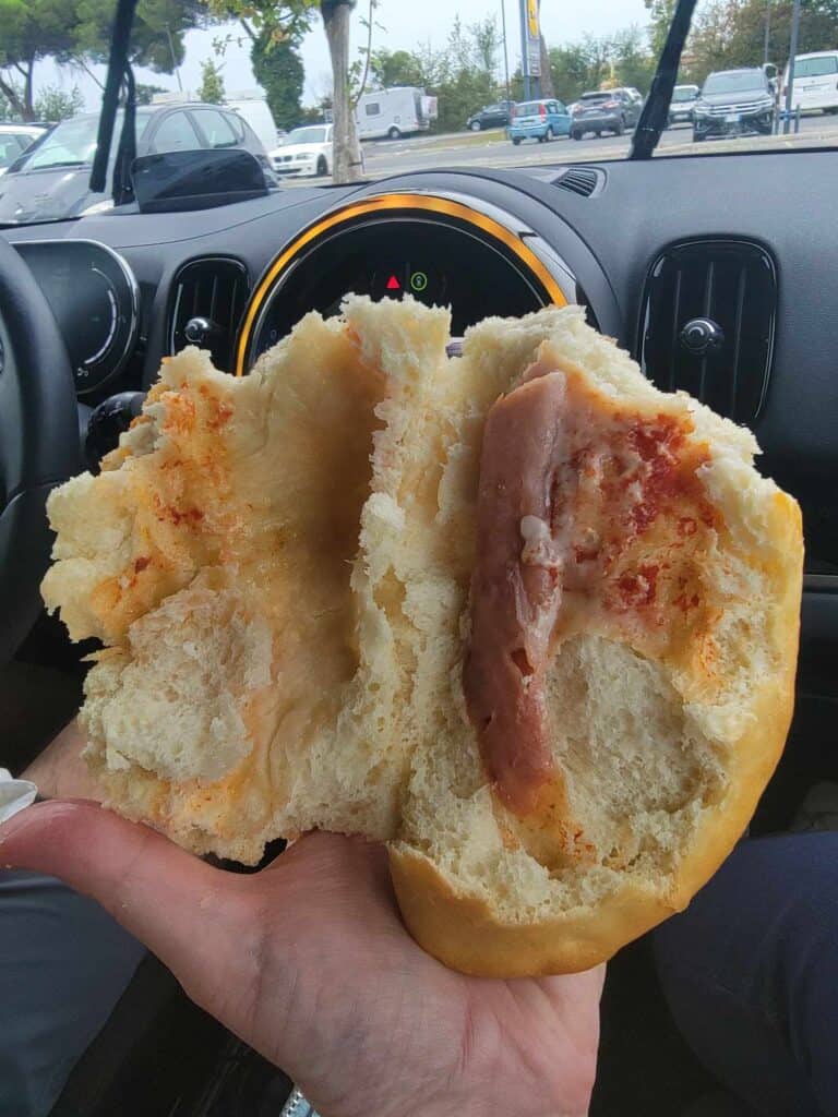 Some white bread, opened up to reveal one sad piece of ham, and the orange stain of a tiny amount of tomato paste