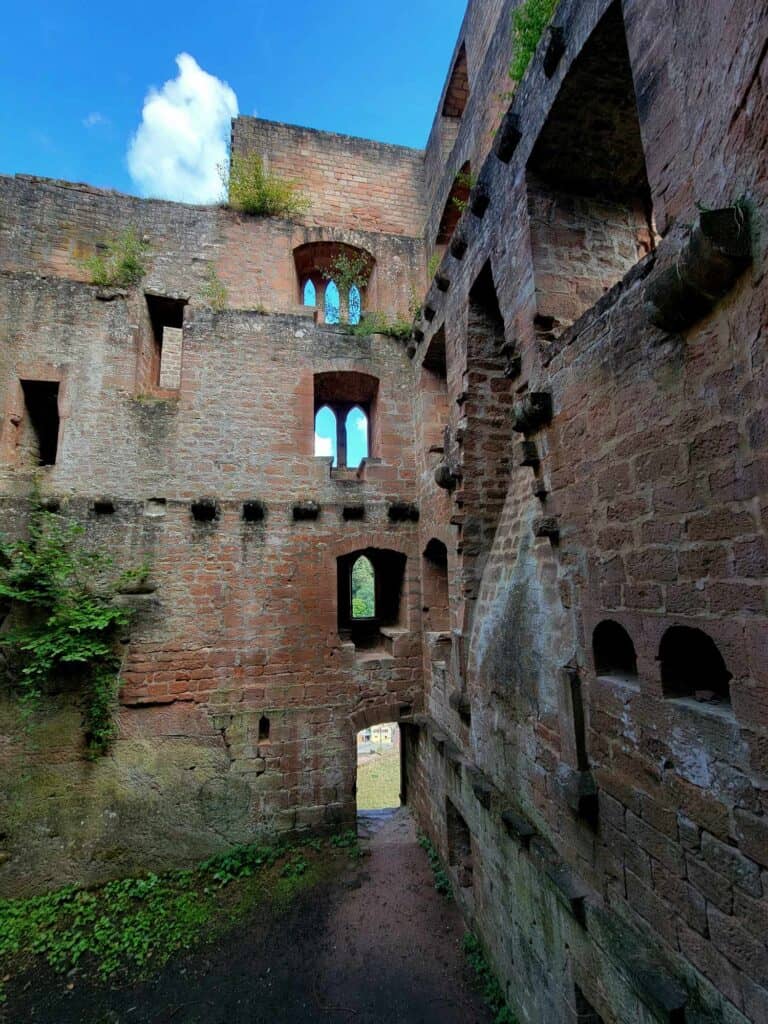 A three story corner and two walls with windows, doors, floor joists, ovens and a fireplace.