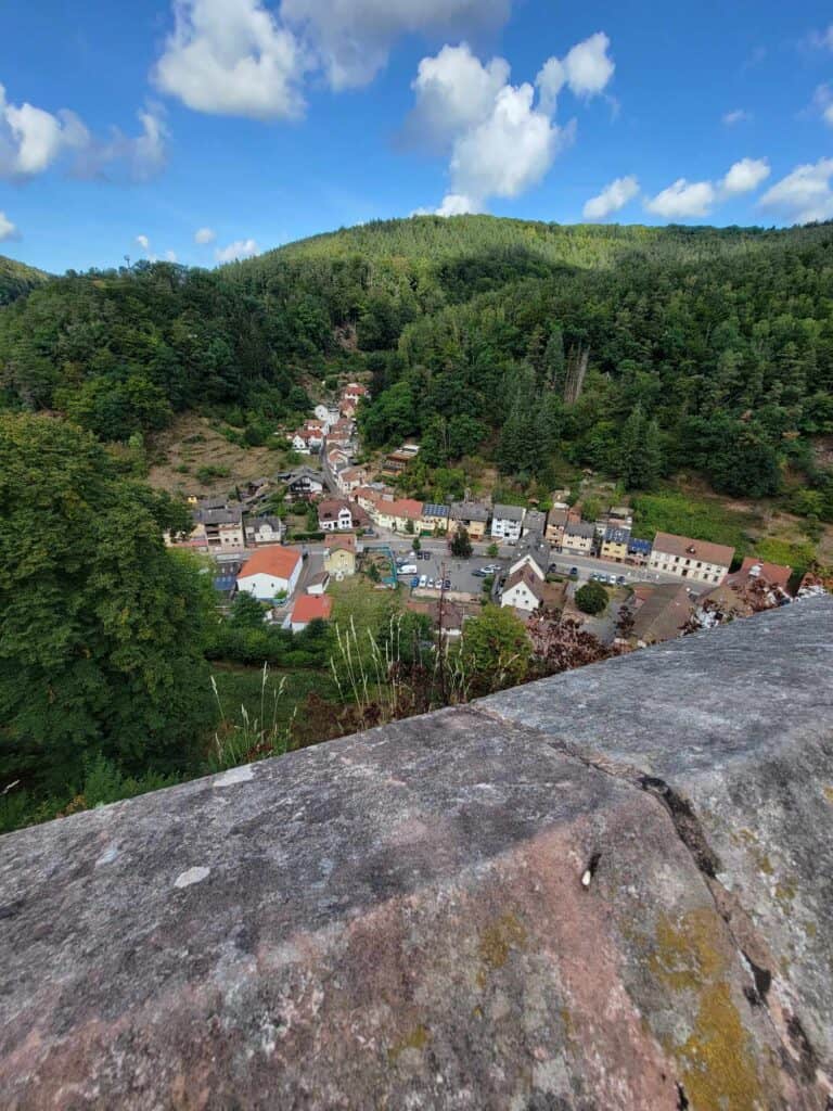 A stone rail looking out over a small village with maybe 50 houses, with pitched roofs