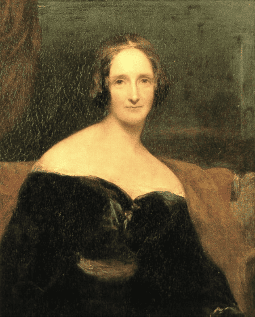 A woman with brown hair and eyes in an off-shoulder black dress looking upward into the distance