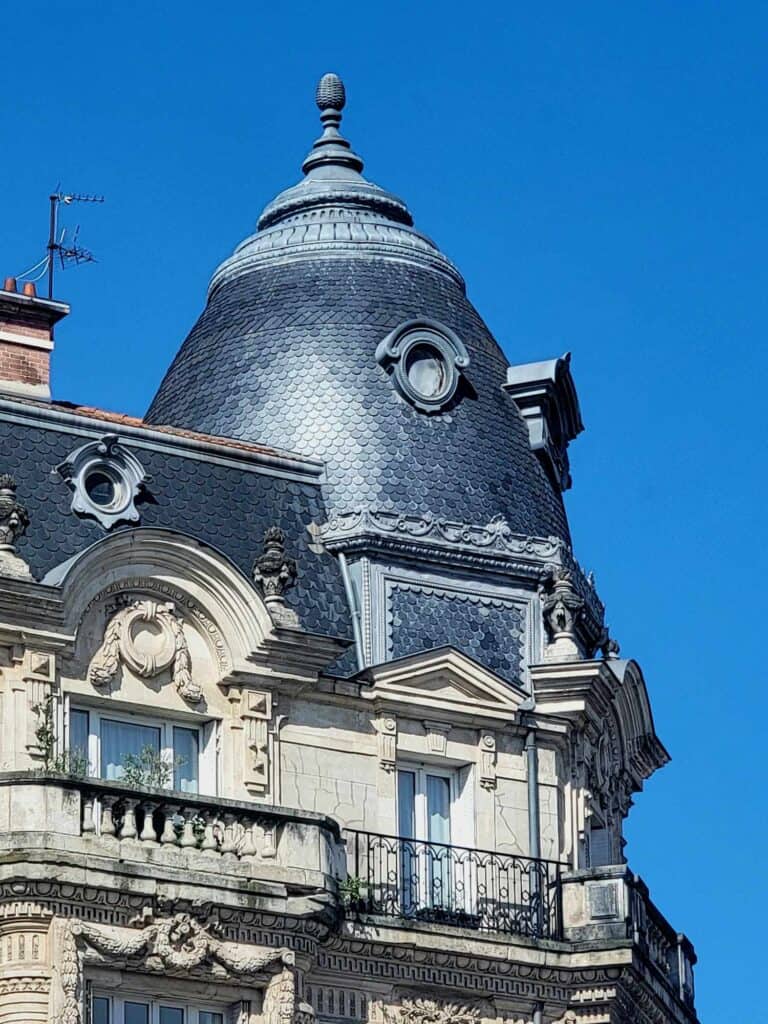 A dome shaped roof tiled in black slate with round dormers