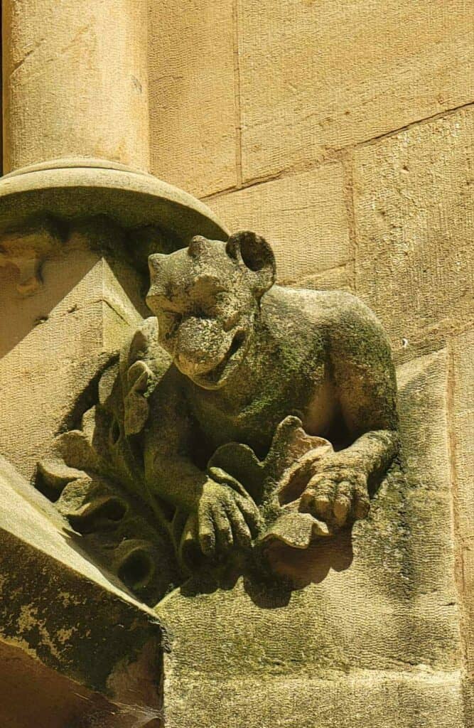 A gargoyle that looks like a smiling devilish frog