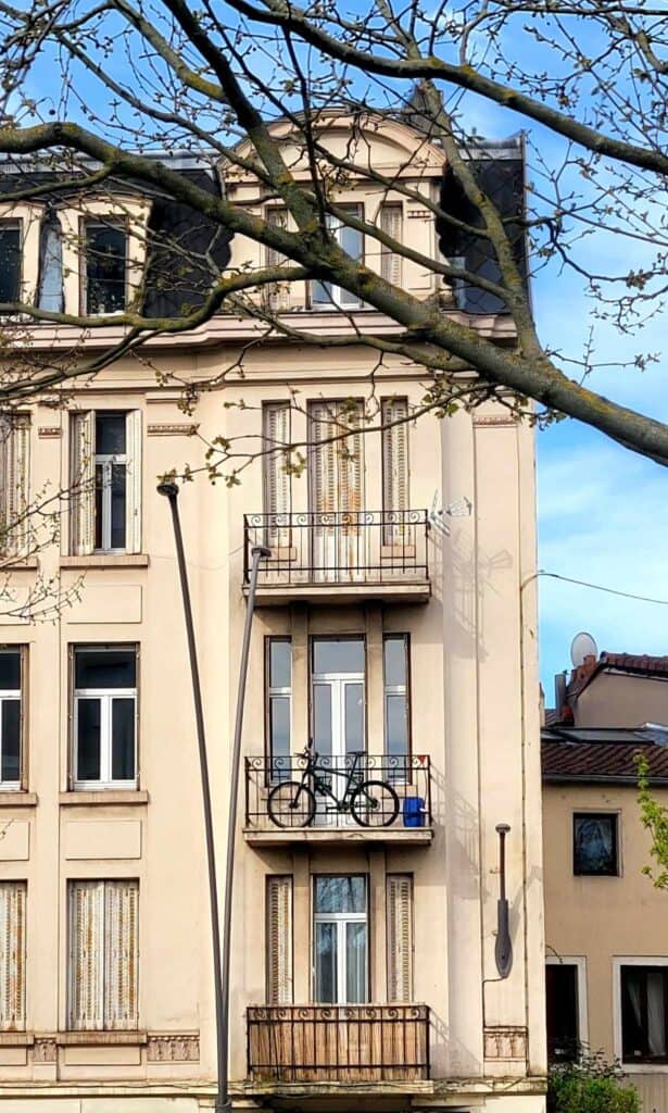 Art Nouveau style apartment building in white stone with a bicycle on a balcony