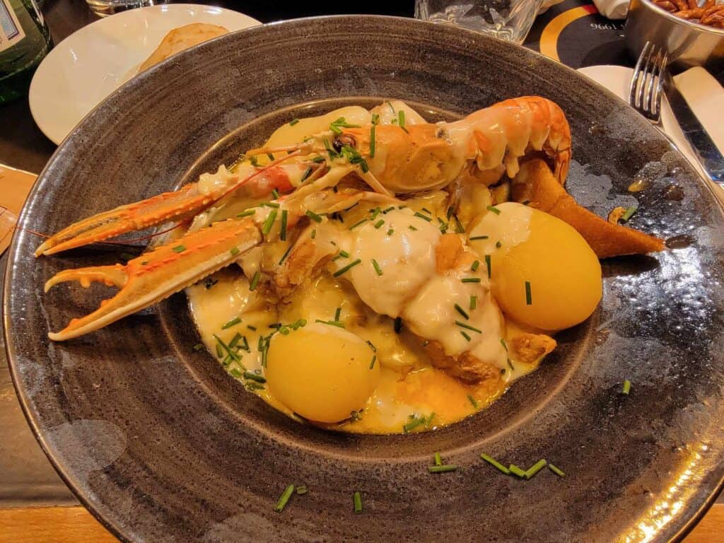 Saurkraut with boiled potatoes and several kinds of seafood including a large whole langoustine on top