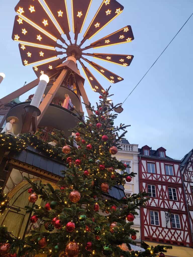 Half timbered buildings in red and white, with a Christmas pyramid and christmas tree in the fore