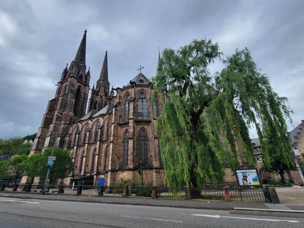 The church from another angle with a large weeping willow in the foreground