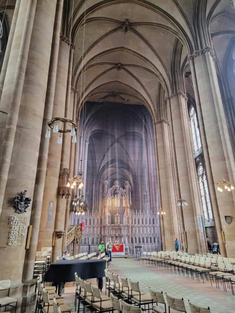 A church with a printed drapery hanging and showing what is concealed behind it.