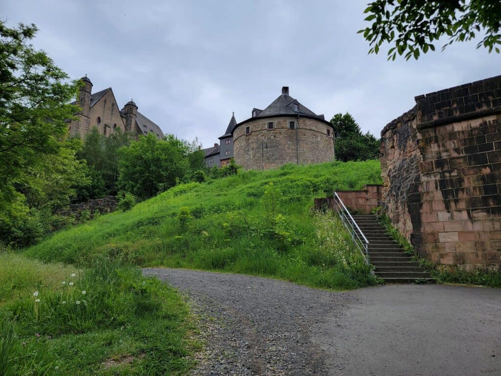 A low wide stone tower sits on a grassy hill with stairs leading up to it