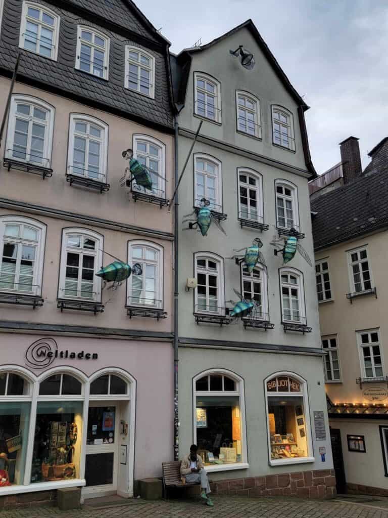 A building with large green models of flies on the face