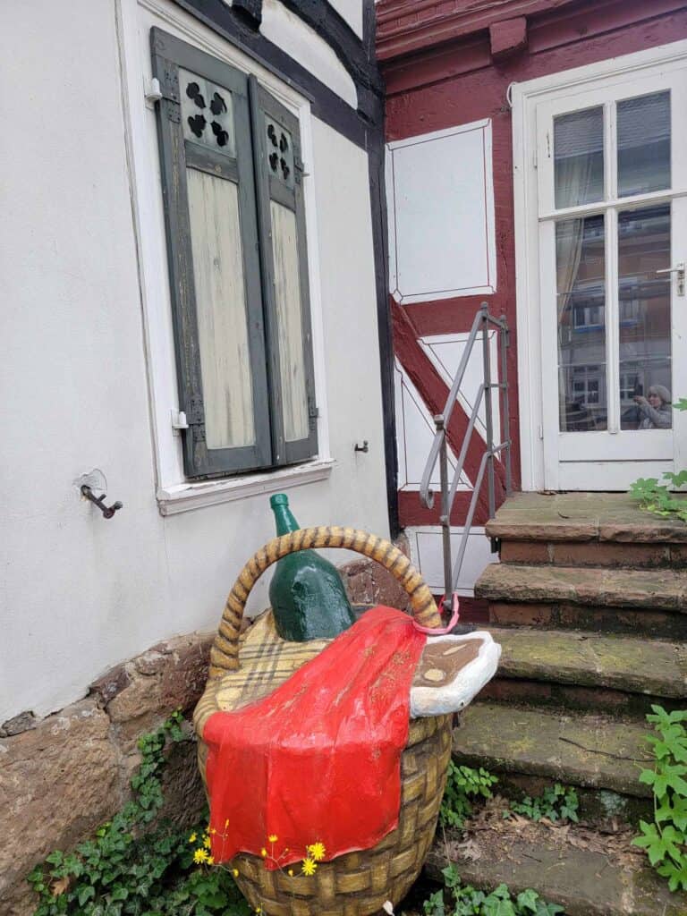 Sculpture of a basket with a red cloth, a plaid cloth, a wine bottle, and a steak