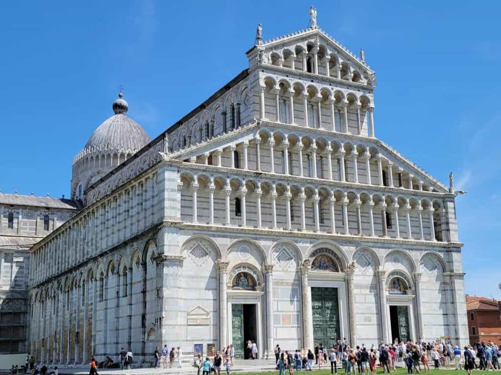 A bright white marble facade with arches and layers of thin white columns