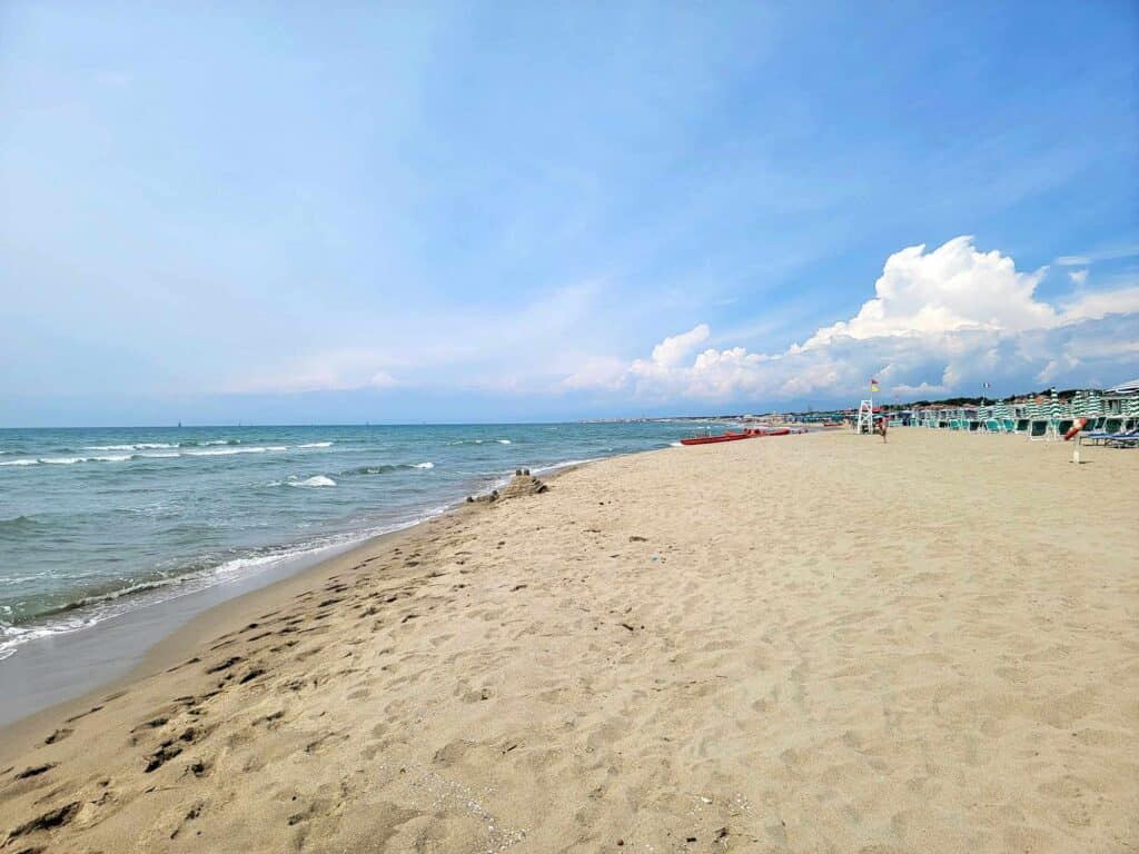 A sandy shore with blue sky and white clouds