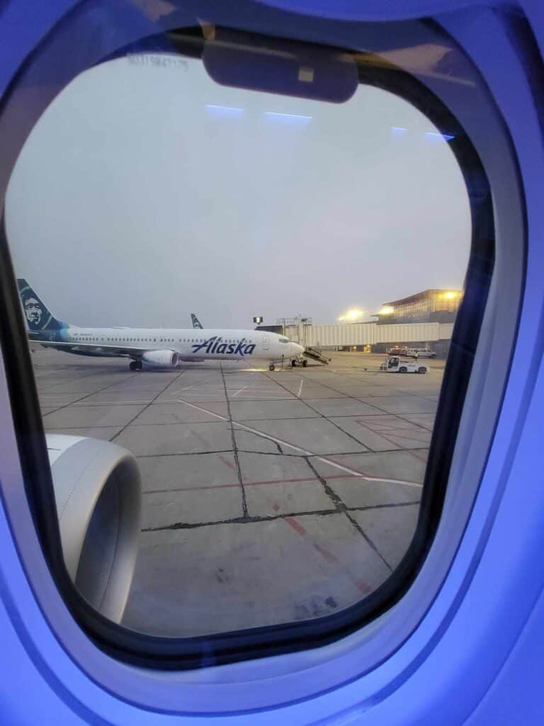 An Alaska Airlines plane seen through the window of an Alaska Airlines plane