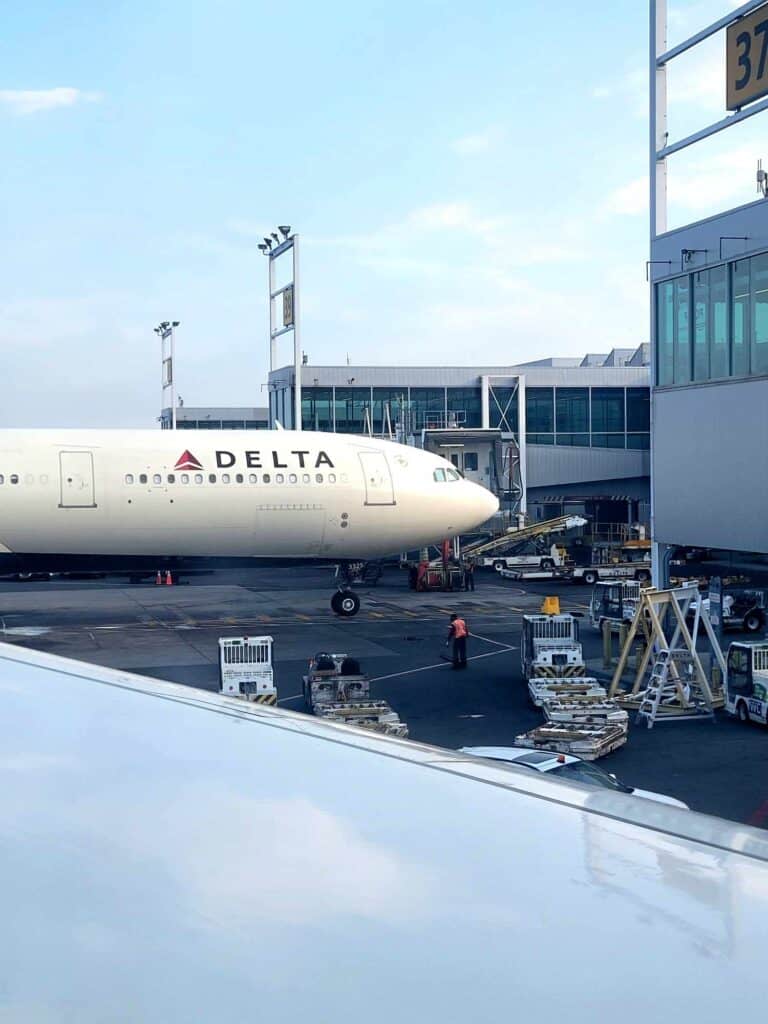 A delta airlines plane pulled up to the gate