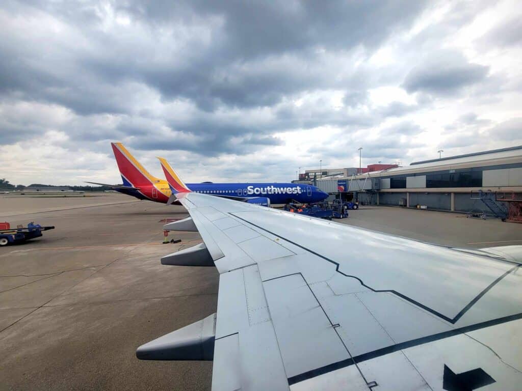 A Southwest airplane on the tarmac from the perspective of a seat on another plane over the wing