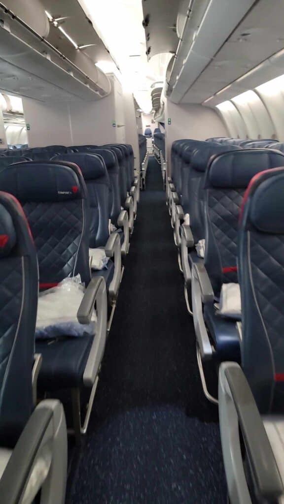 An empty Delta aircraft from the perspective of walking down the aisle to a seat