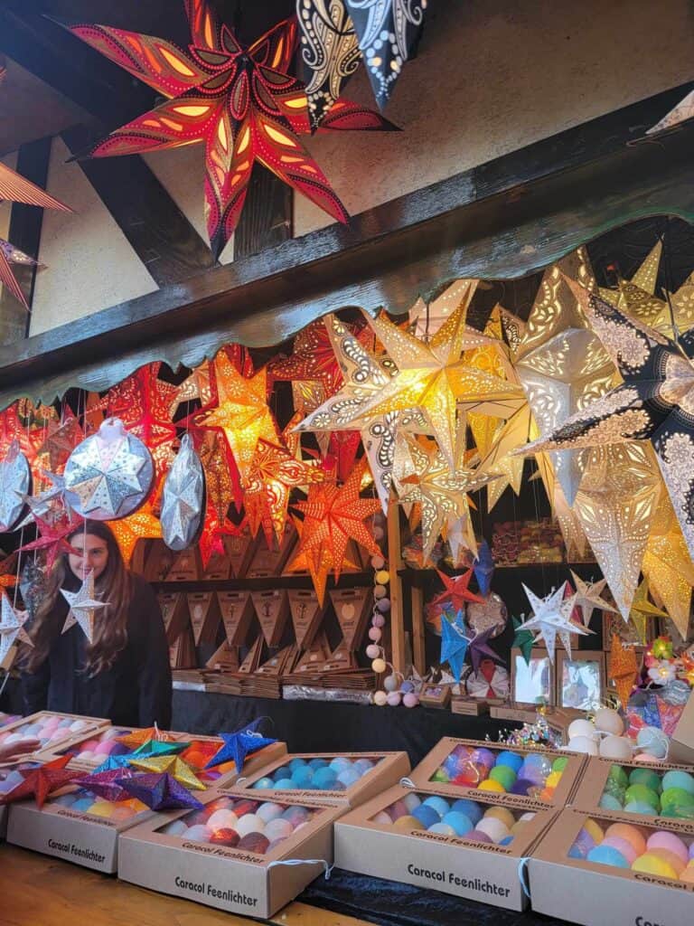 A booth with pillar candles and a ceiling hung with illuminated paper stars