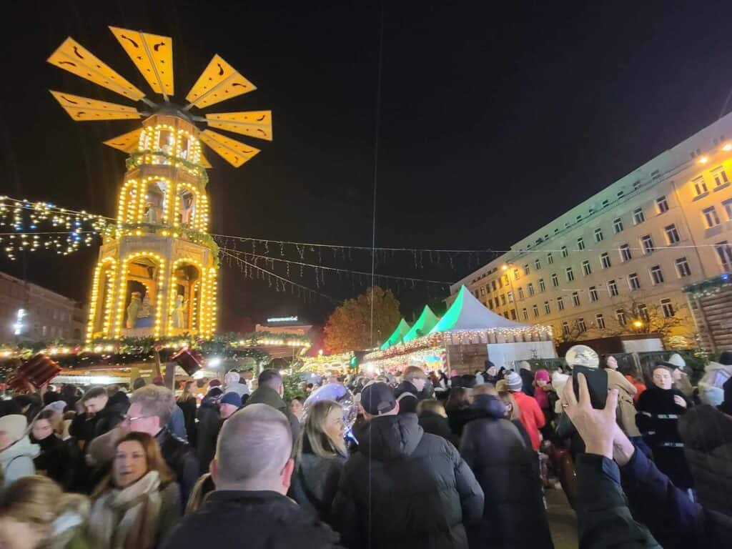 A tall Christmas pyramid with a twirling top and market stalls underneath