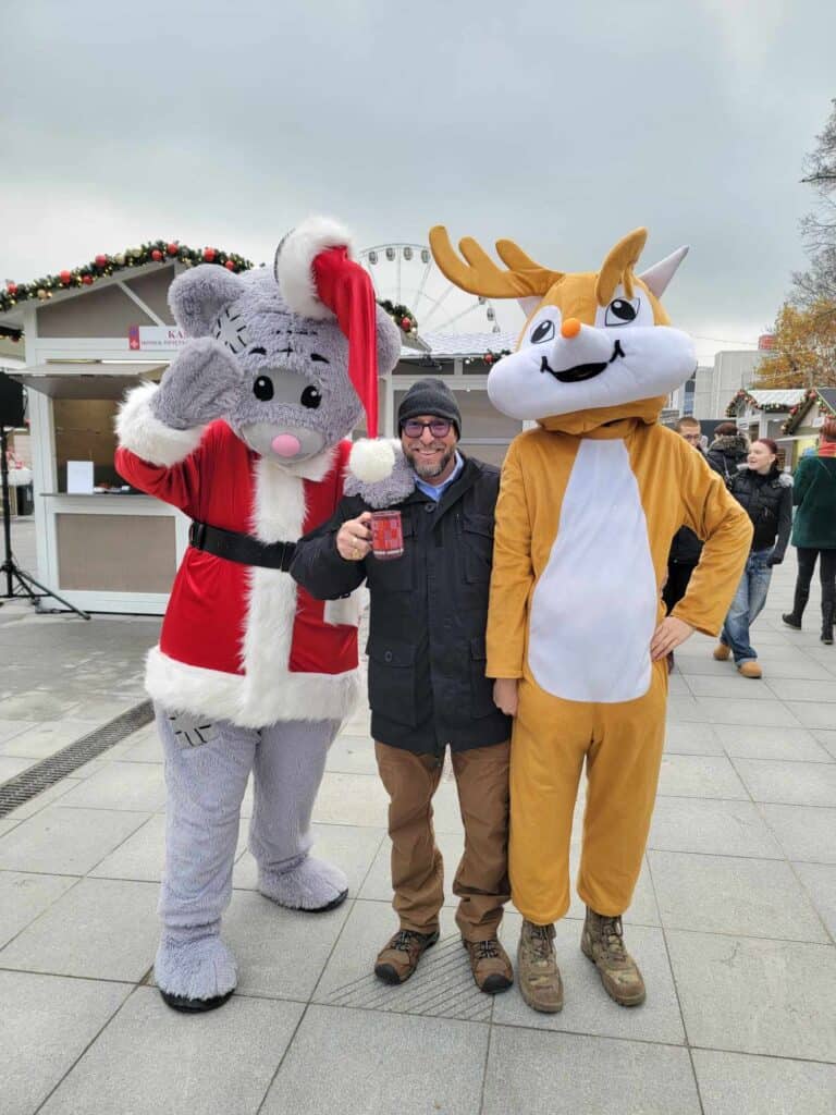 A man standing with Santa Mouse and a reindeer