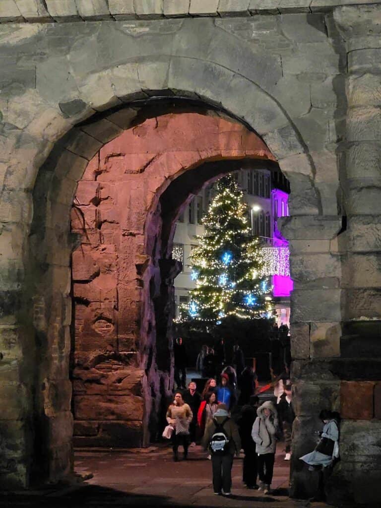 A Christmas tree as seen through a double set of large stone archways