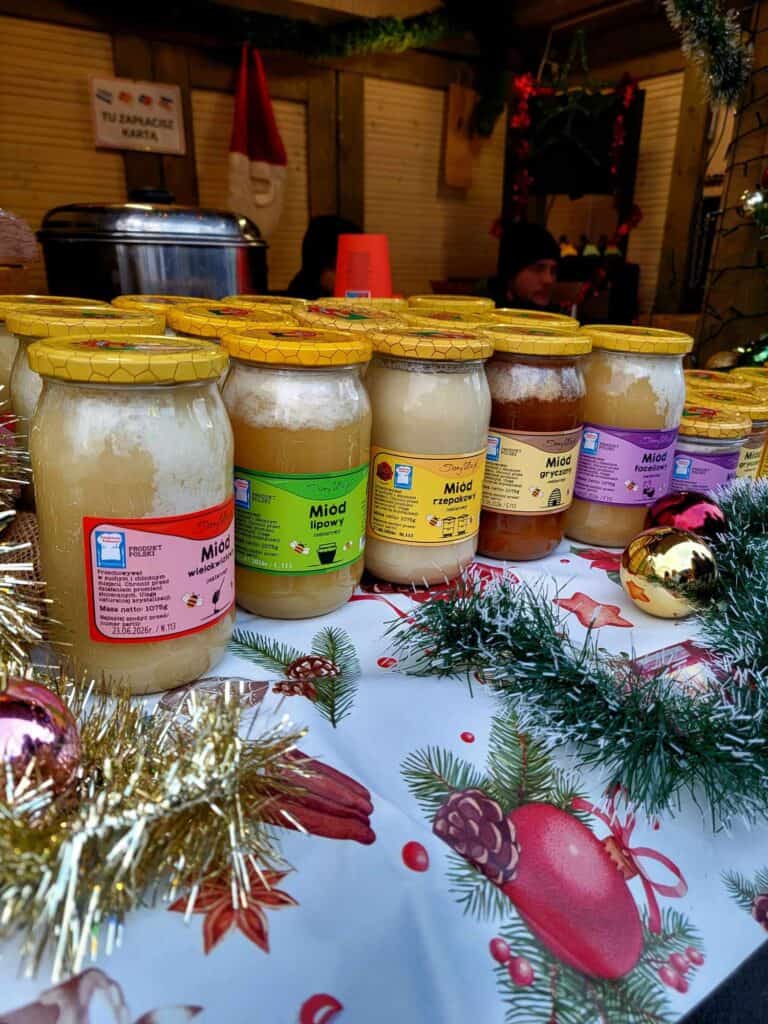 Jars of honey with polish labels on a Christmas tablecloth