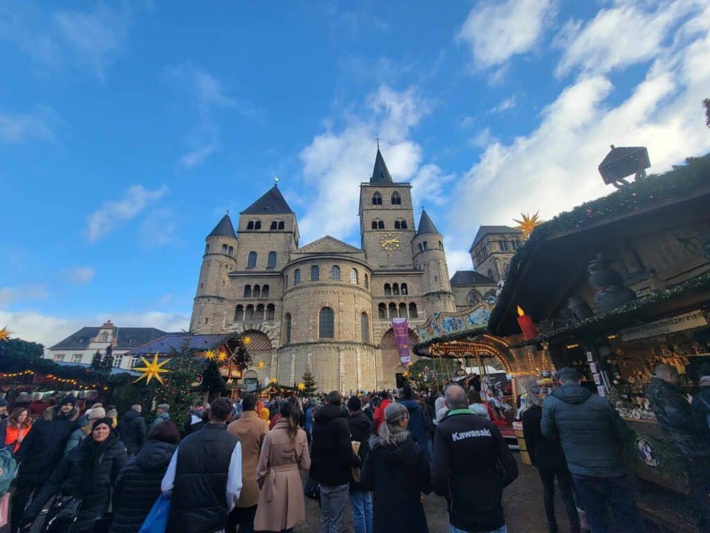 The Romanesque cathedral with the market in front and a blue sky with white clouds