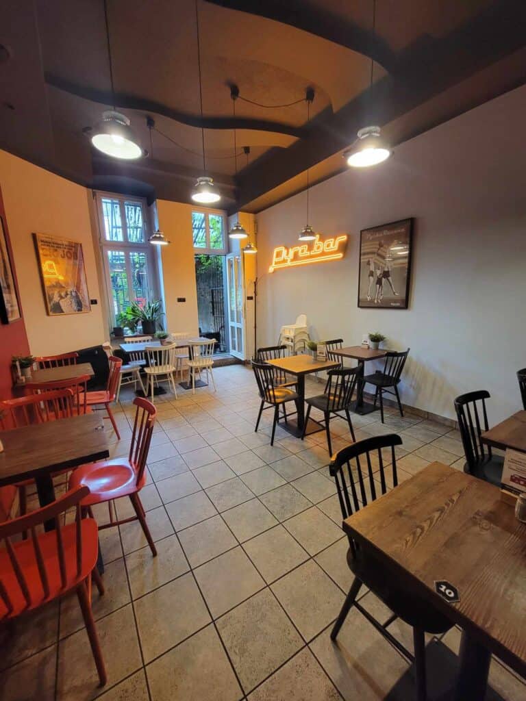 Tile floor, wood tables, and chairs in black, red, and pale blue