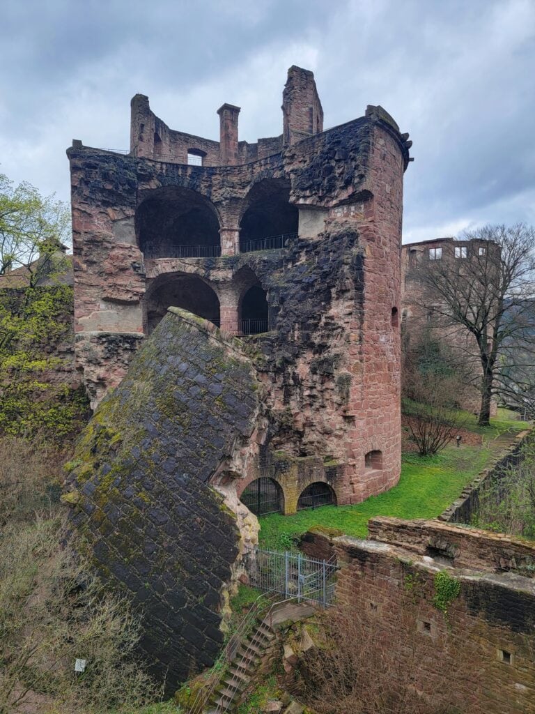 A castle tower with half of it broken off and sloughing down a hill