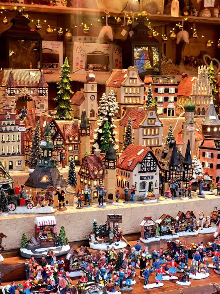 A display of Christmas village pieces, houses, churches, trees, etc.