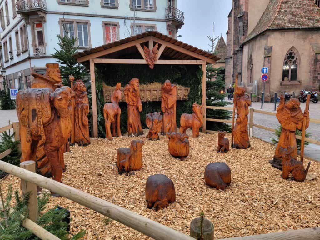 A carved wooden nativity scene in daylight