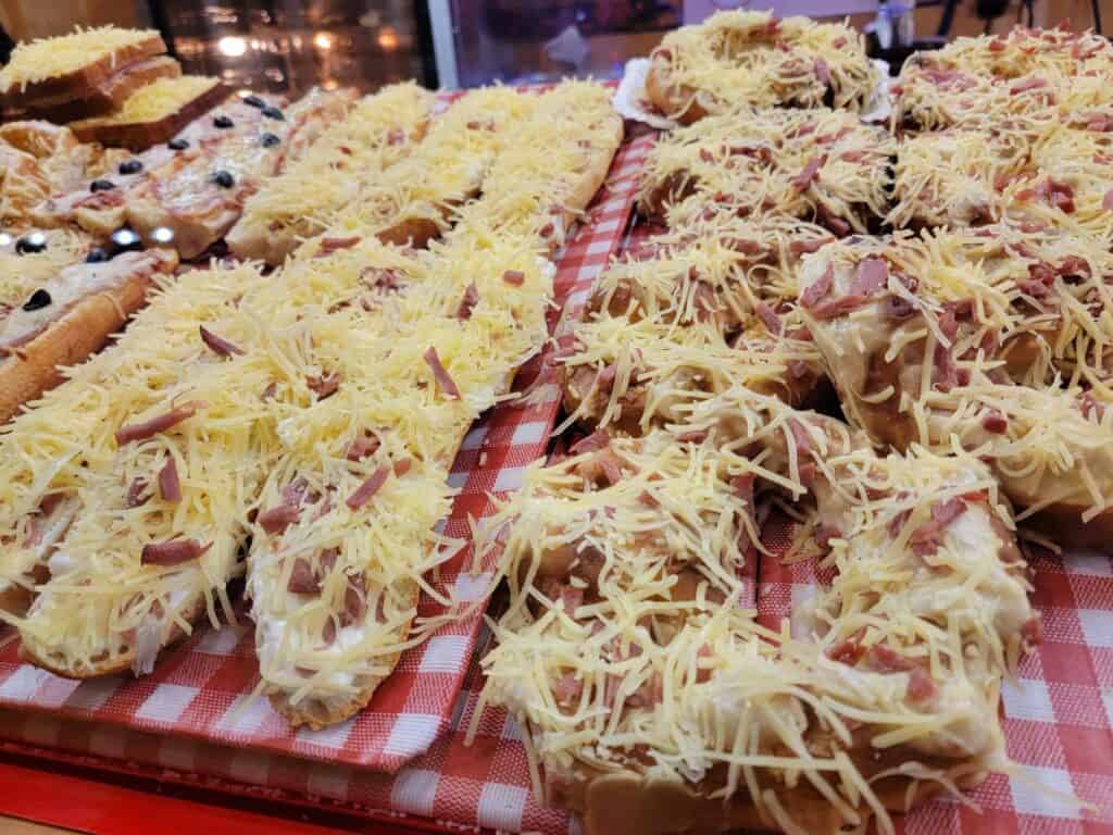 Flambée baguettes covered with meat and cheese ready to be put in the oven